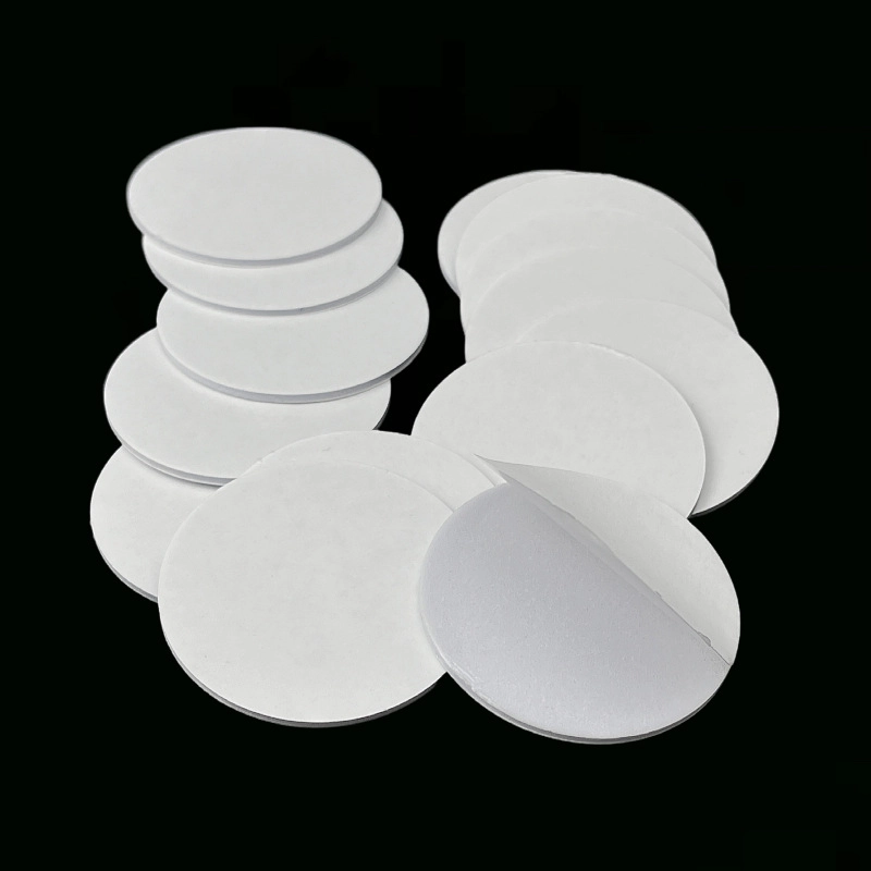 White circular EVA double‑sided adhesive pad with partial release liner peeled back